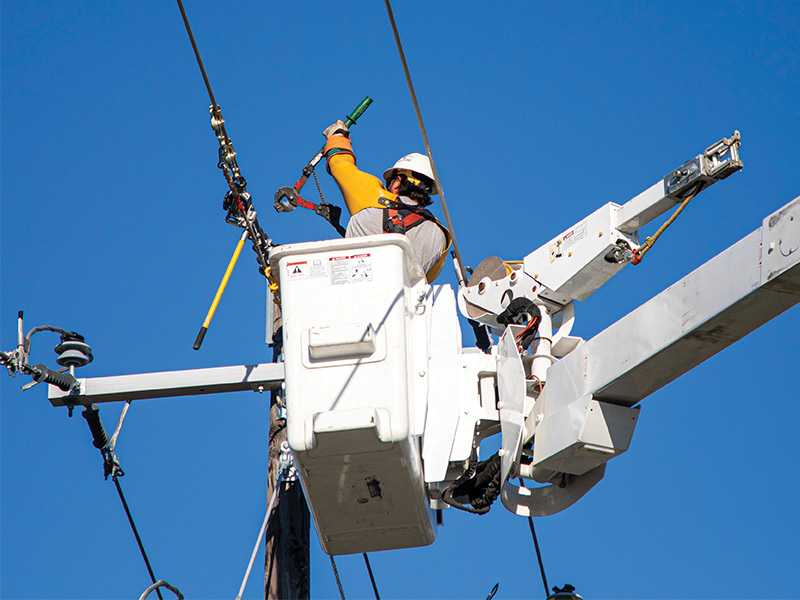 CoServ linemen were able to relocate several utility
poles along Stacy Road in McKinney without interrupting
service to a single Member. Photo by KEN OLTMANN