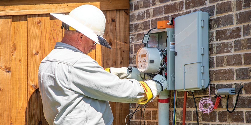 Power Quality Technician Mike Gray installs a monitor
on an electric meter to measure power fluctuations. Photo by SARA ELLIS