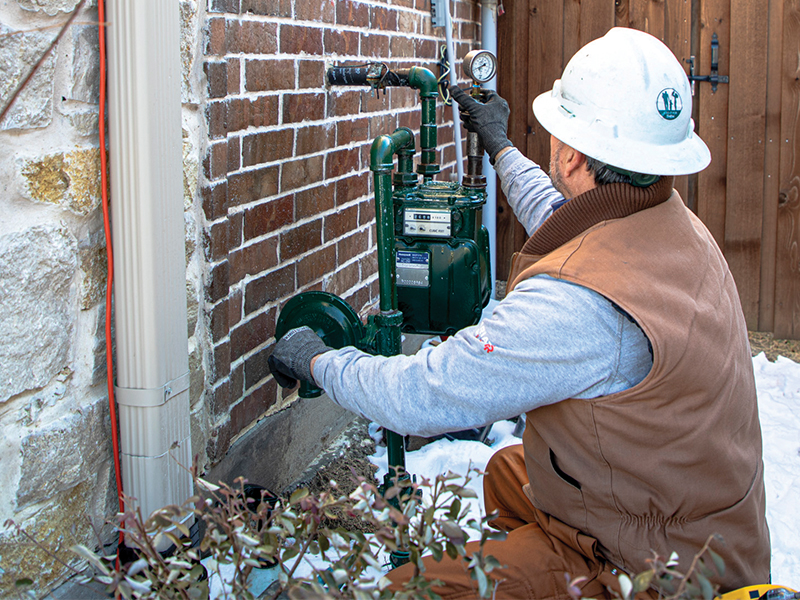Gas Service Technician Tino Acosta checks the pressure on a residential meter. Photo by KEN OLTMANN