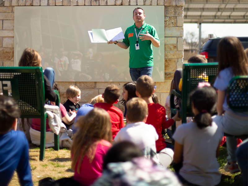 Energy Education Specialist Justin Porterfield reads to a class of third-graders at Pilot Point Elementary school for Read Across America Day.