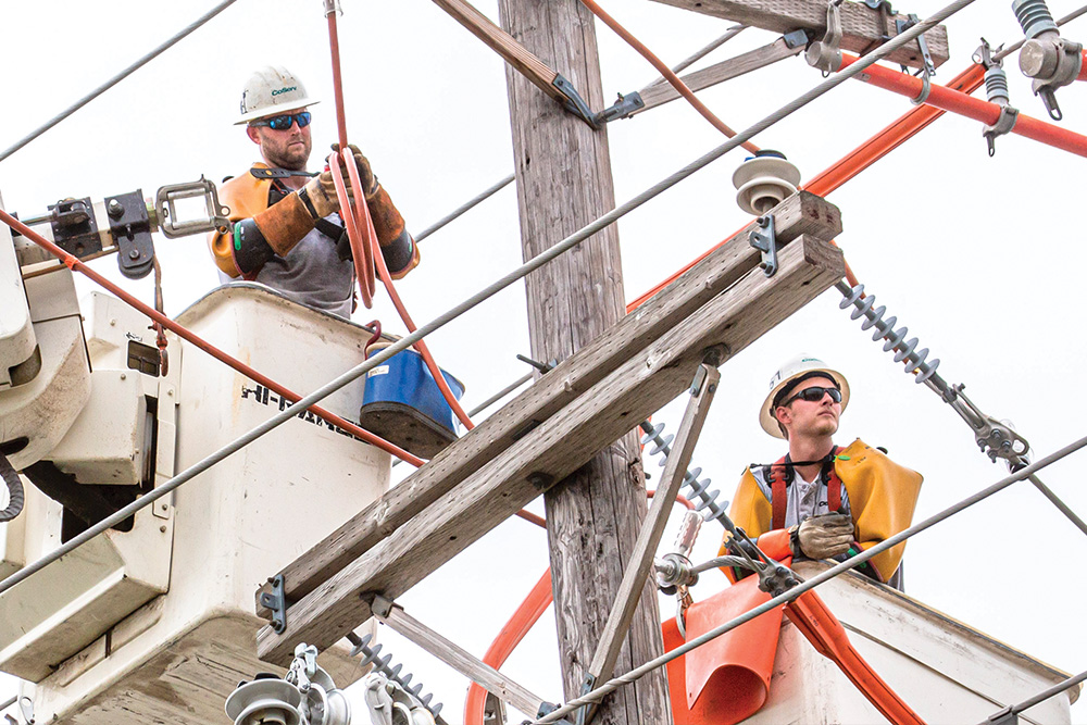 CoServ linemen run jumpers to energize lines in Flower Mound. Photo by NICHOLAS SAKELARIS