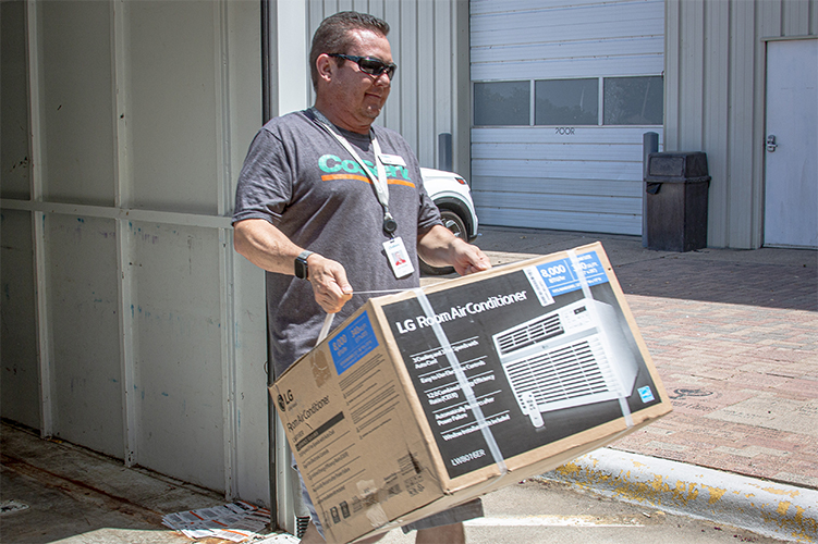 CoServ’s Energy Education Specialist Justin Porterfield delivers air conditioners to Christian Community Action this month.