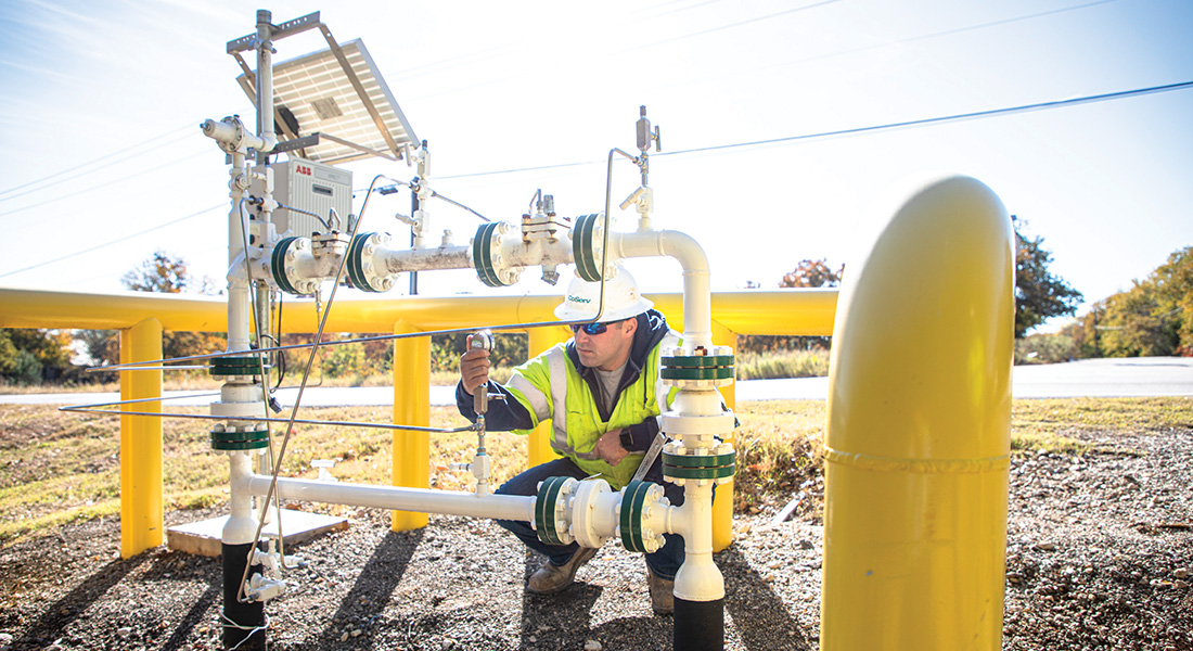 Alex Molander, Gas Construction Crew Supervisor, checks the pressure on a bypass for a gas regulator. Photo by KEN OLTMANN