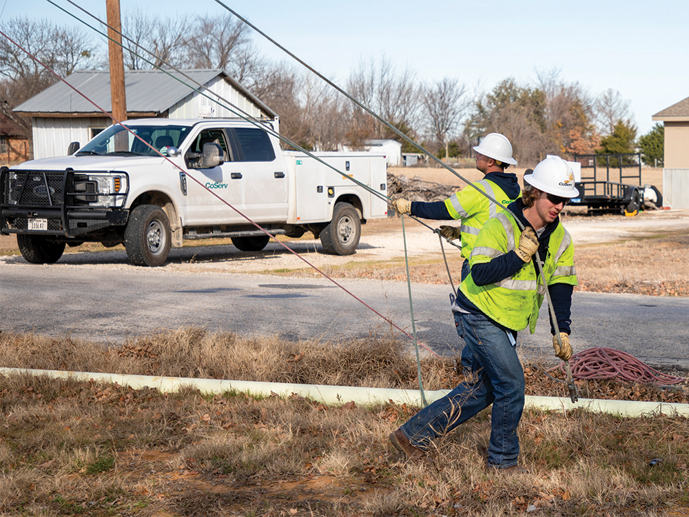 Linemen attach the rope to the new wire. Photo by KEN OLTMANN