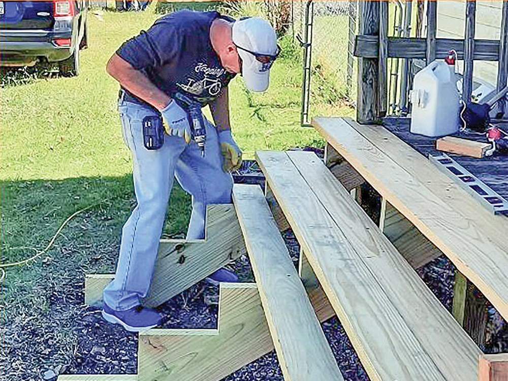One volunteer works to finish new porch steps. Photo courtesy of Hearts for Homes