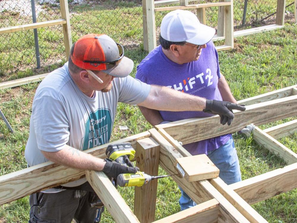 CoServ Employees Conan Tearney and Tony Arias secure two sections of the ramp frame together at a Member's home in Justin. Photo by NICHOLAS SAKELARIS/CoServ