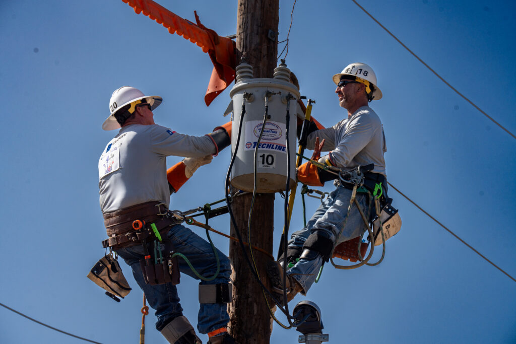 CoServ's 2023 Linemen Rodeo Senior Journeyman Team members Alex Garza and Chris Hammonds compete in the Transformer Changeover event at the Texas Lineman Rodeo Association's annual Lineman Rodeo in Seguin, TX.