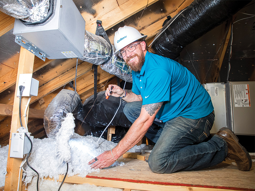 Craig Lay crawls into the attic to check the insulation.