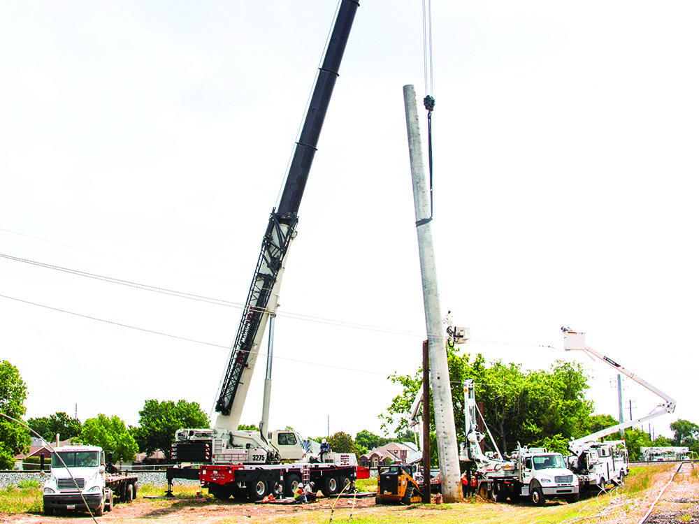 A crane prepares to place the pole after the hole is dug. Photo by NICHOLAS SAKELARIS