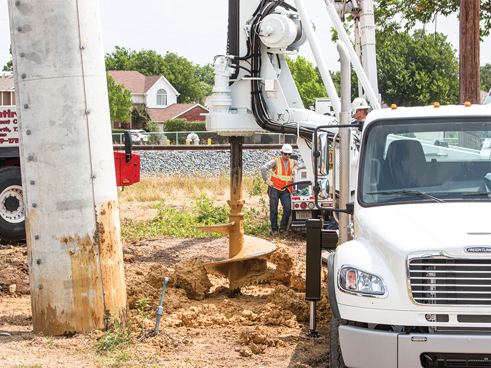 The new digging truck bores a hole for a concrete pole in Lewisville. Photo by NICHOLAS SAKELARIS