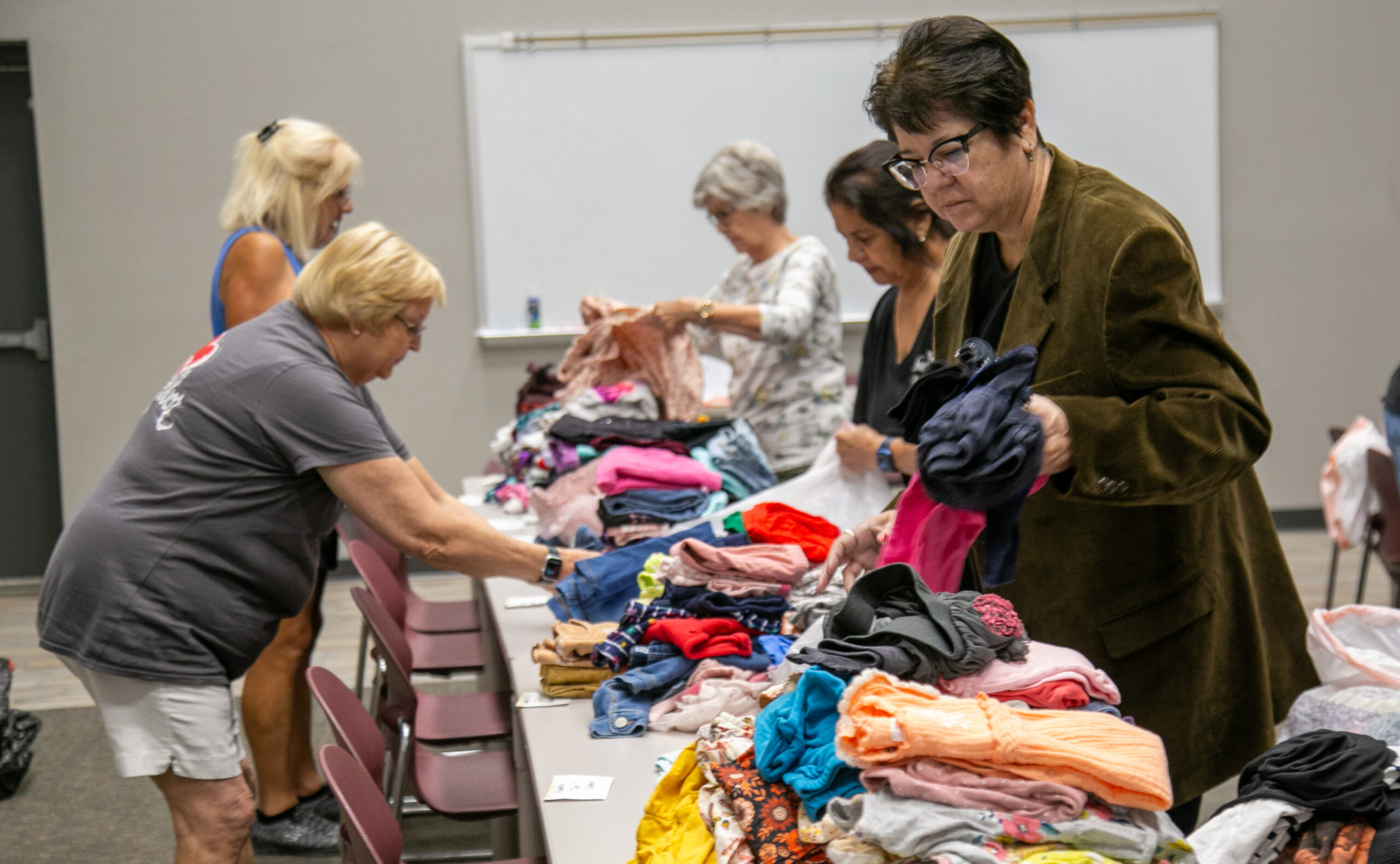 Love Thy Neighbor volunteers sort clothes.  