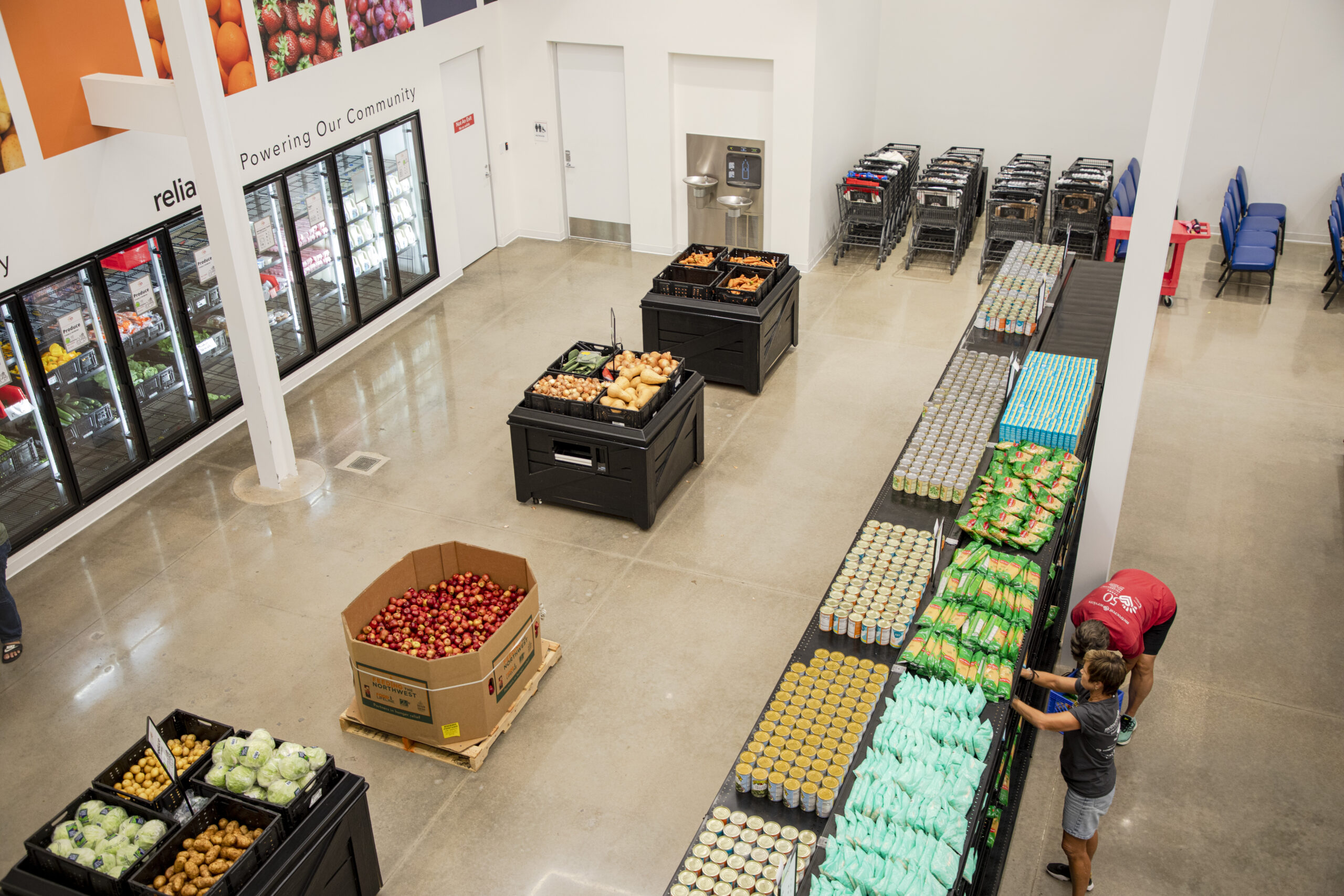 The food bank at the new Metrocrest Services facility is set up like a grocery store. Here, volunteers stock the shelves. The CoServ Charitable Foundation awarded a grant to Metrocrest Services to help purchase food and other needed items.  Photos by NICHOLAS SAKELARIS/CoServ