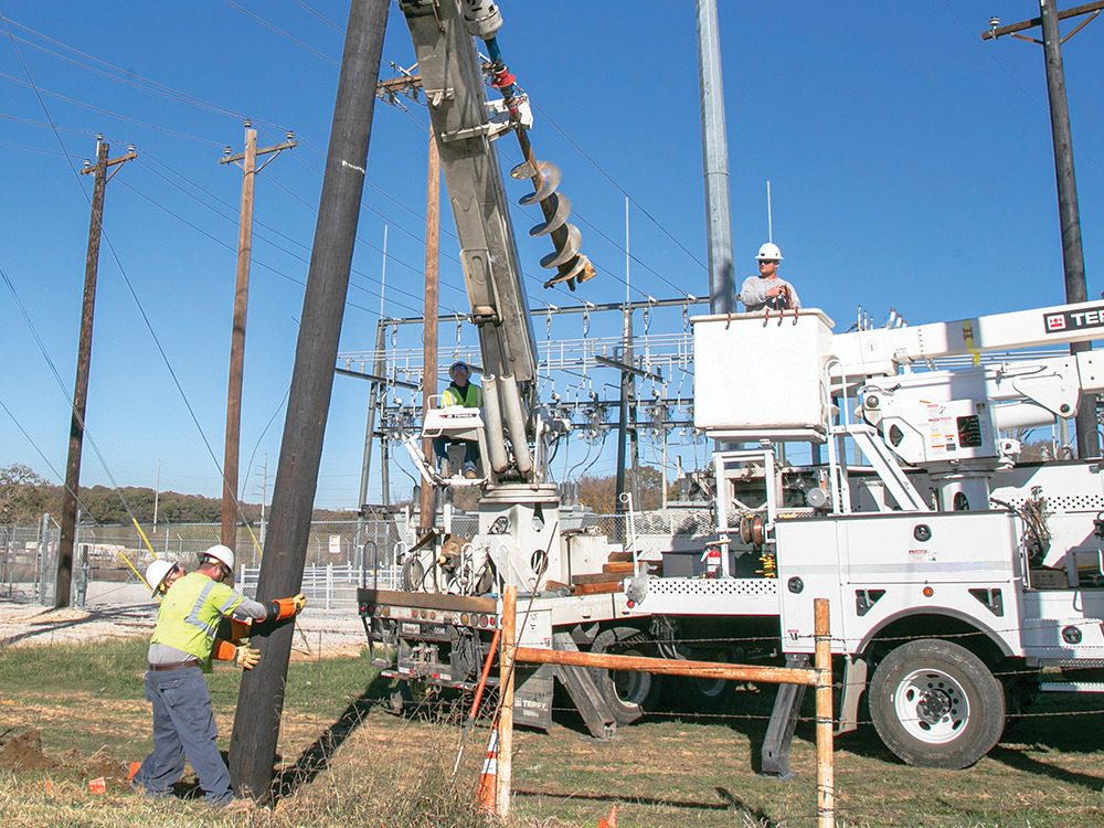 A new pole is placed in the ground at the Aubrey substation. 