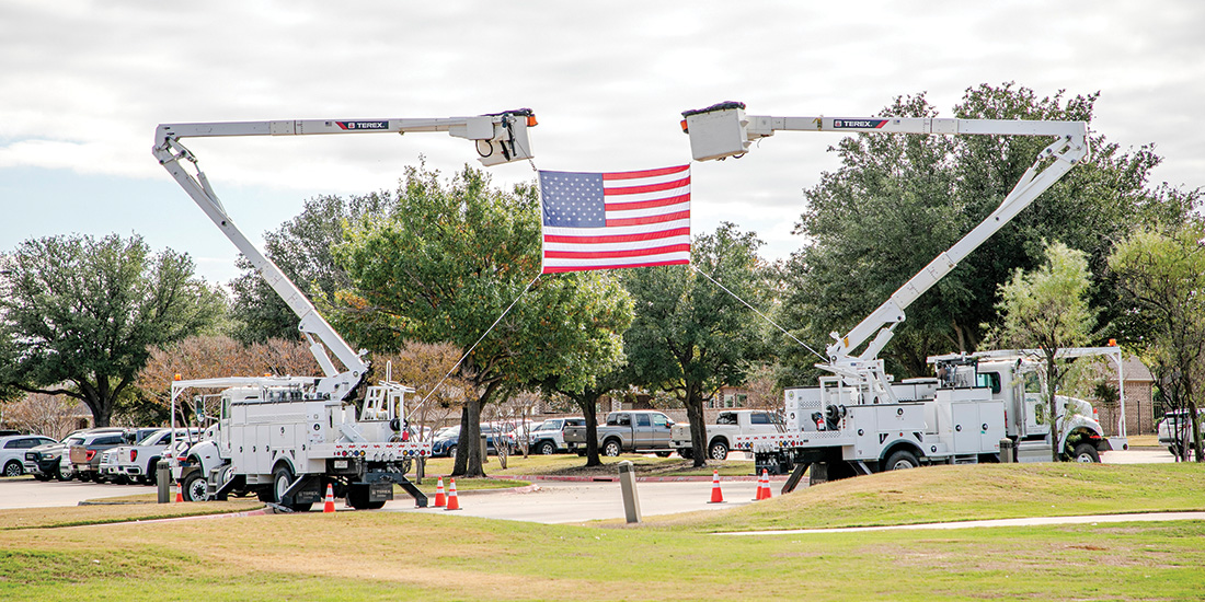 CoServ bucket trucks display the American flag at the Flower Mound Chamber First Responders Breakfast. Photo by KEN OLTMANN