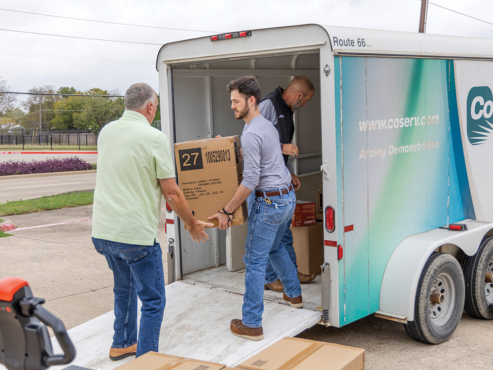 CoServ's Walker Sims and Randy Copeland hand off donations to Scott Hildebrand with ACO.