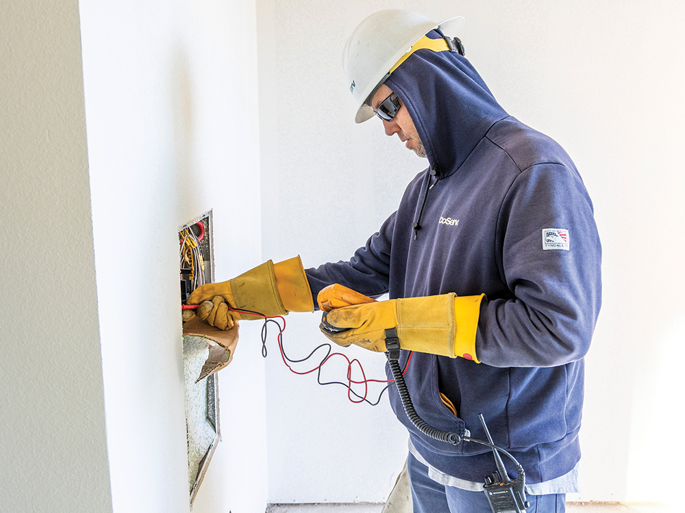 Senior Meter Tech Matthew Ingram tests the voltage
in an apartment after the meter was installed.