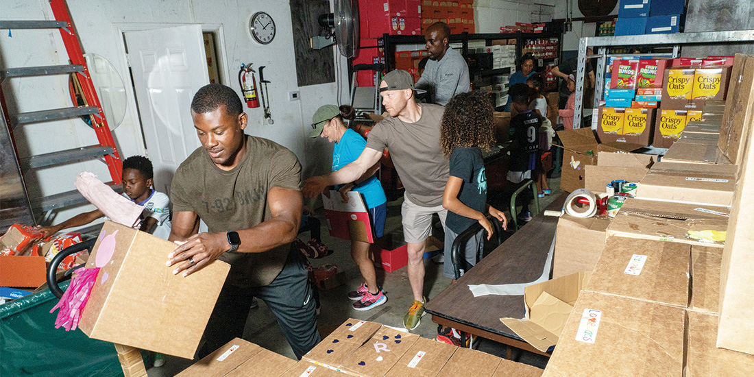 A volunteer group packs boxes of food for Lovepacs for the Thanksgiving break at their Frisco location. Lovepacs gives boxes of food to students on the free lunch program to take home during school holidays. Photos by BRIAN ELLEDGE