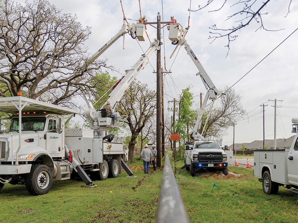 Linemen use bucket trucks to hold up the power lines while installing a new pole in Aubrey.