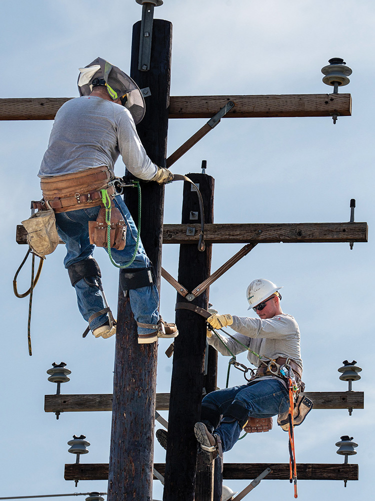 Lineman Class GT Tyler Garrett 
and Meryk Slattery practice 
circling a pole during the CoServ Climbing School.