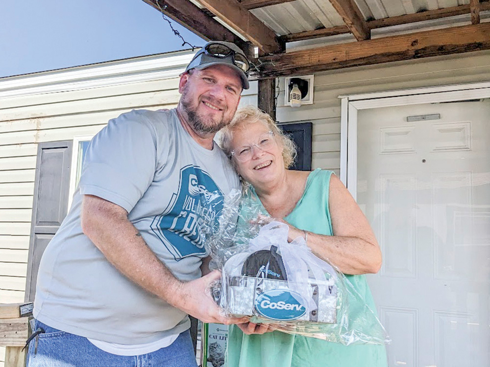 F: Conan Tearney, who leads CoServ’s ramp-building crew, presents a gift basket to Jill Tanner, a CoServ Member from Sanger, and a Texas Ramp Project recipient