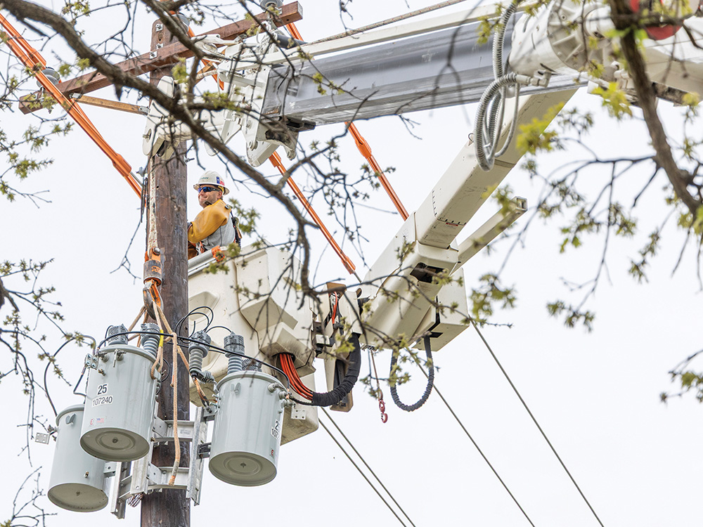 Linemen Installing new pole, transformer and underground service line.