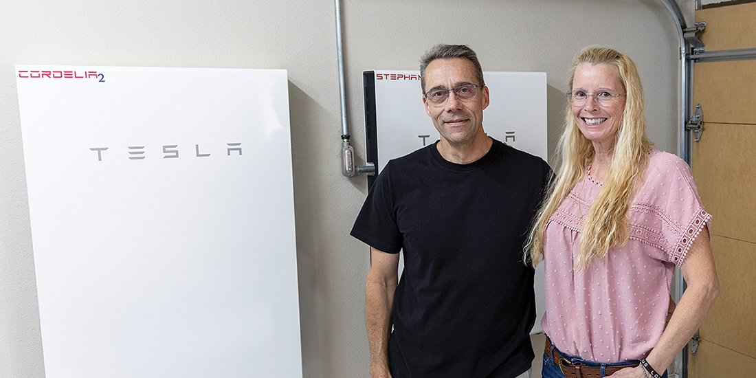Paul Palmier and his wife, Donitta Palmier, stand in their garage with two of their five Tesla Powerwalls. Photo by KEN OLTMANN | CoServ