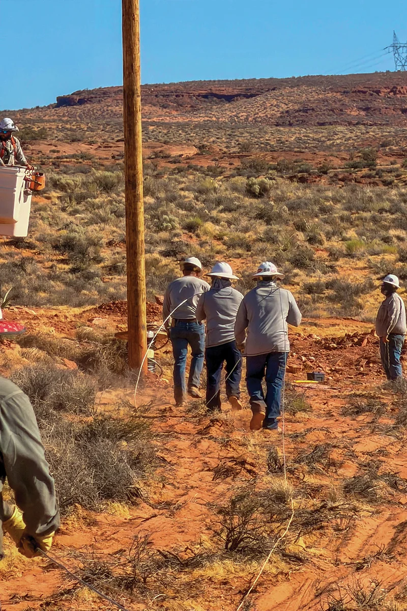 Jacob Barreiro, Lineman Journeyman and Dustin Rucks, Crew Supervisor, running line 
to a resident’s home.